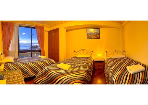 two beds in a room with yellow walls at HOTEL WENDY MAR in Copacabana
