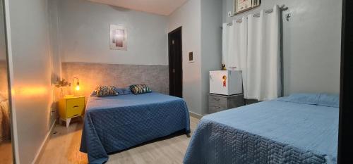 a bedroom with two beds and a yellow night stand at Hostel Cidade Velha in Belém