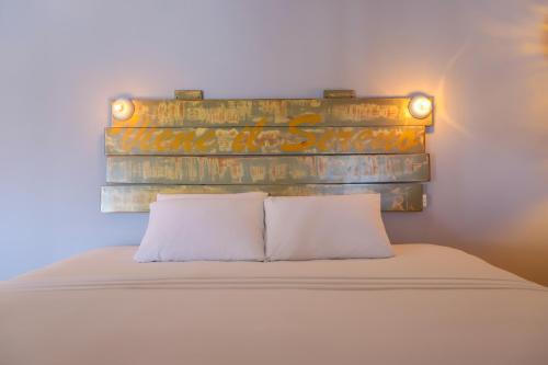 a bed with a rusty headboard with two white pillows at 40 Cañones in Mahahual