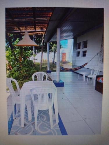 - une table et des chaises blanches sur la terrasse dans l'établissement Bangalô Cristal, à Itaparica Town