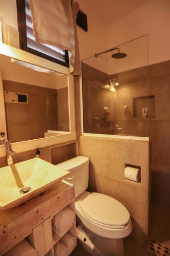 a bathroom with a sink and a toilet and a mirror at 40 Cañones in Mahahual