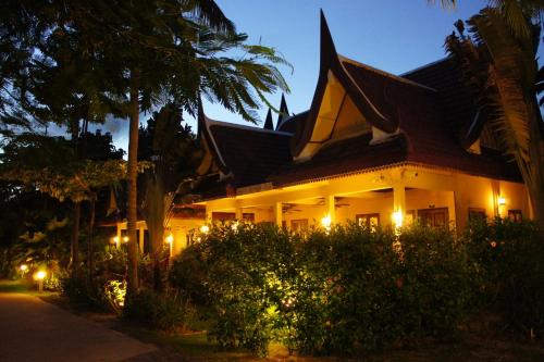 a building with lights in front of it at night at Palm Village in Rawai Beach