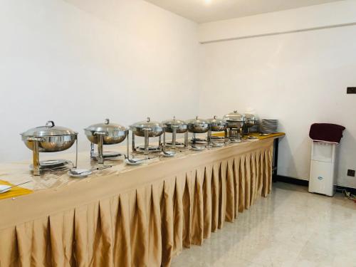 a long table with a row of pots and pans at Carmel Hill Resort in Ambagamuwa