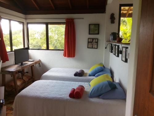 um quarto com 2 camas e uma secretária com um computador em Studio Formana em Florianópolis