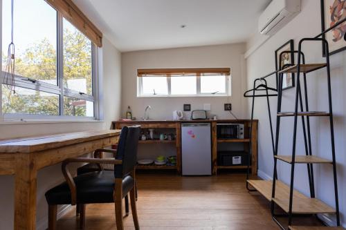 a kitchen with a wooden table and a refrigerator at Villa Viva Cape Town in Cape Town