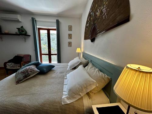 a bedroom with a bed with pillows and a lamp at Domus Ars Home & Spa in Massa Lubrense