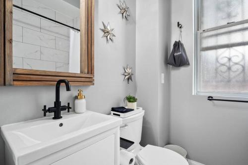 Un baño blanco con lavabo e inodoro. en Luxury Living: Grand 7BR/5BA near Everything, en Tower Grove