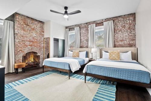 Un dormitorio con dos camas y una pared de ladrillo. en Luxury Living: Grand 7BR/5BA near Everything, en Tower Grove