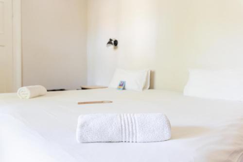 a white bed with a towel on top of it at Villa Viva Cape Town in Cape Town