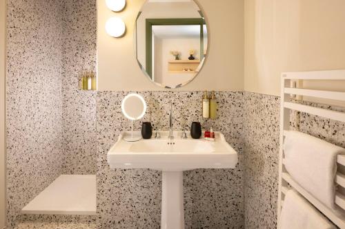 uma casa de banho com um lavatório e um espelho em Hostellerie Briqueterie & Spa Champagne em Vinay