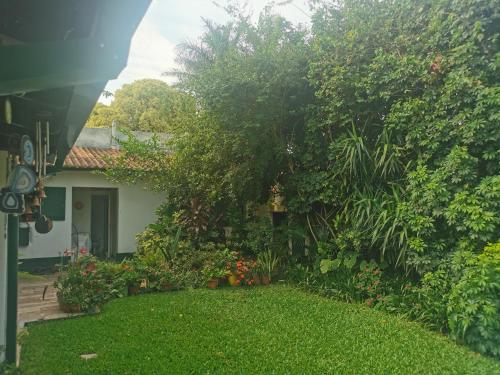 una casa con un jardín de flores y árboles en Cuarto privado separado de la casa principal y con entrada independiente en Corrientes