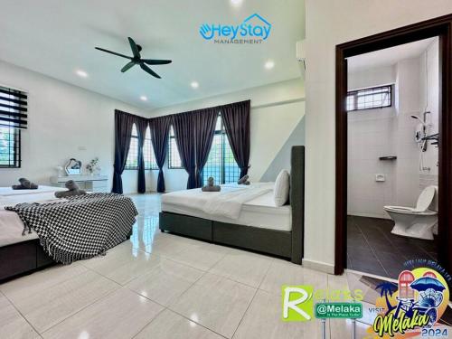 1 Schlafzimmer mit 2 Betten und einem Deckenventilator in der Unterkunft Villa 20Pax4B3B PrivatePool /Karaok/Pooltable/BBQ in Malakka