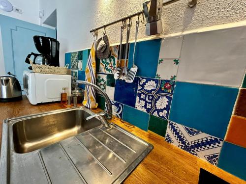 una cucina con lavandino in acciaio inossidabile e piastrelle blu di Domus Ars Home a Massa Lubrense