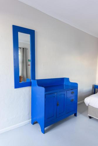a blue dresser with a mirror in a bedroom at Villa Viva Cape Town in Cape Town