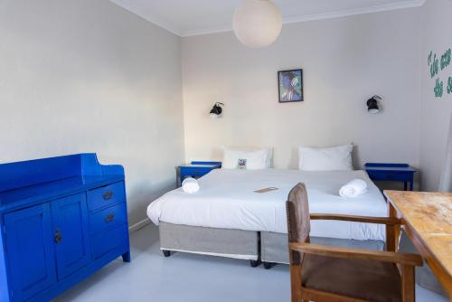 a bedroom with a blue dresser and a bed at Villa Viva Cape Town in Cape Town