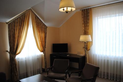 a hotel room with a desk and a window at Churchill-Inn in Vinnytsya
