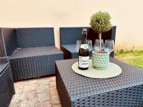 a table with two bottles of wine and a potted plant at « Maison Sauge » et son jardin in Deauville