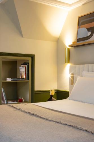 a bedroom with a bed and a book shelf at Briqueterie Champagne, A Beauvallon Hotel & Spa in Vinay