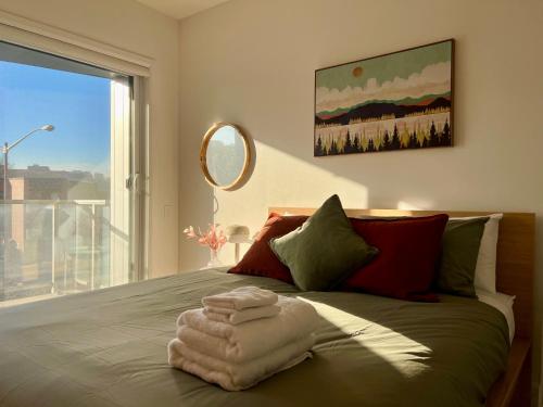 a bedroom with a bed with towels on it at Le Kaméleon - Lumineux et moderne, condos au centre-ville in Quebec City