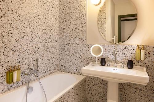W łazience znajduje się umywalka i lustro. w obiekcie Hostellerie Briqueterie & Spa Champagne w mieście Vinay