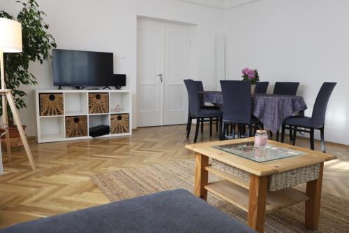 巴拉頓博格拉爾的住宿－Attila Vendégház，客厅配有桌子和电视