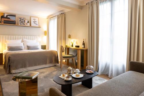 ヴィネにあるHostellerie Briqueterie & Spa Champagneのベッドとテーブルが備わるホテルルームです。