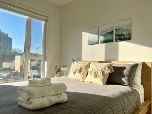 a bedroom with a bed with towels on it at Le Kaméleon - Lumineux et moderne, condos au centre-ville in Quebec City