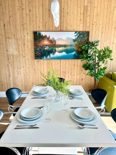 a white table with plates and wine glasses on it at Le Kaméleon - Lumineux et moderne, condos au centre-ville in Quebec City