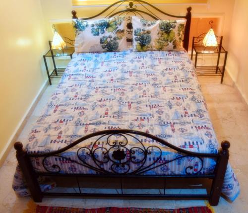 Una cama con edredón en un dormitorio en Confort et tradition au coeur de la ville - Faire demande de réservation -, en El Jadida