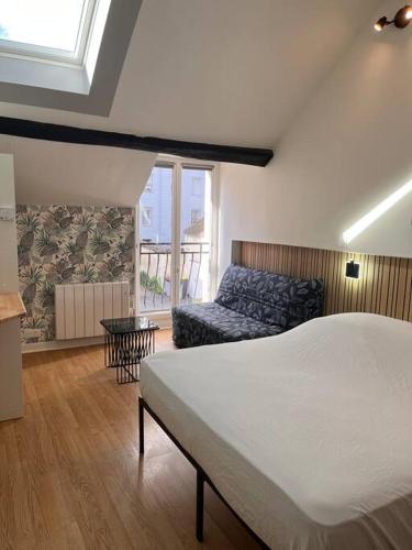 a bedroom with a bed and a couch at Studio duplex Hypercentre au calme avec parking in Fontainebleau