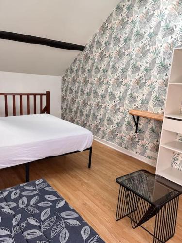 Kleines Zimmer mit 2 Betten und einem Tisch in der Unterkunft Studio duplex Hypercentre au calme avec parking in Fontainebleau