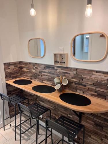 La salle de bains est pourvue d'un comptoir avec trois lavabos et deux miroirs. dans l'établissement Studio duplex Hypercentre au calme avec parking, à Fontainebleau