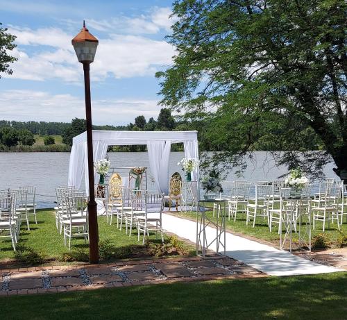a row of chairs and a wedding altar next to a lake at LalaManzi River Lodge in Vanderbijlpark