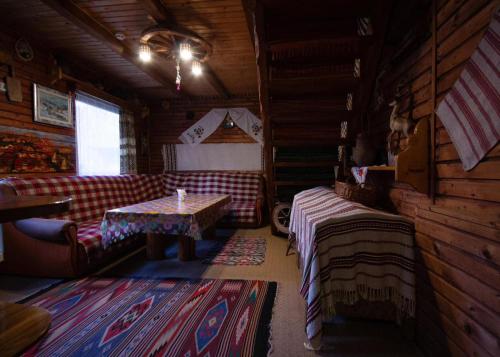 una habitación con sofá y mesa en una cabaña en Котедж 4Сезони en Slavske