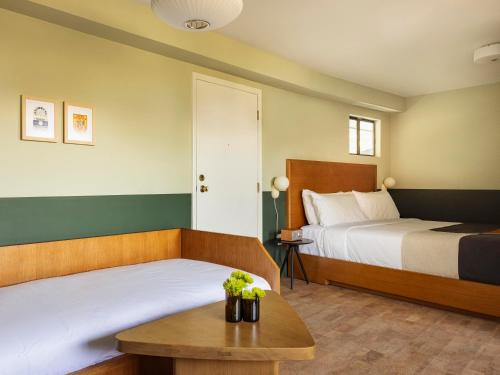 a hotel room with two beds and a table at The Outpost Rocky Mountains in Estes Park