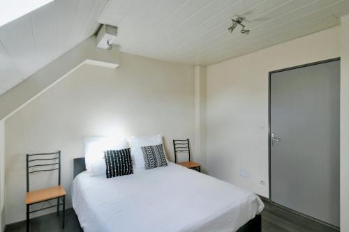 1 dormitorio blanco con 1 cama y 1 silla en Chez Mado, en Hatten
