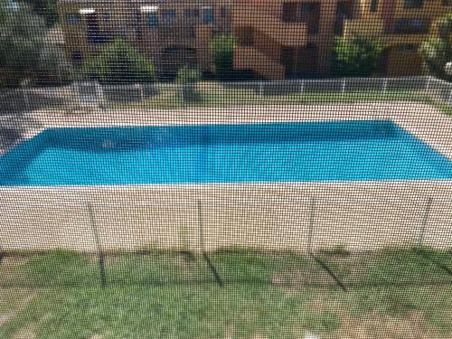 Une piscine est installée derrière une clôture. dans l'établissement Le Camargue, à Arles