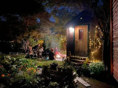 a group of people sitting in a garden at night at Unique homestay in Huddinge