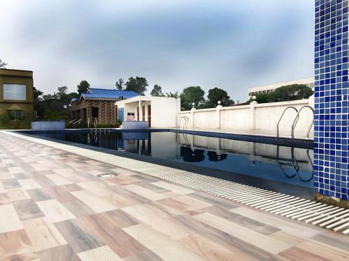 uma piscina com piso de madeira e uma casa em Saikat Saranya Resort, #Mandarmoni #Beach em Mandarmoni