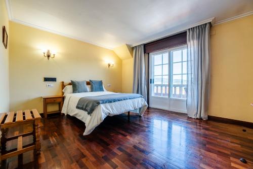 a bedroom with a bed and a large window at Hotel Restaurante GBC Isape in Arcade