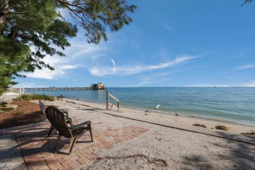 a bench sitting on a brick path next to the beach at Dolphins Run home in Anna Maria