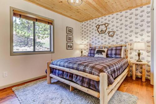 Un dormitorio con una cama grande y una ventana en Monarch Landing, A Cozy Cabin w/360 Mountain Views en Cripple Creek