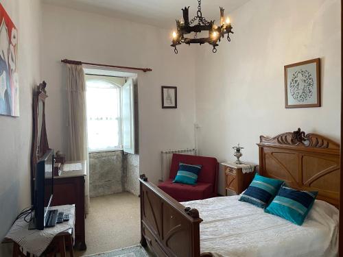 - une chambre avec un lit, une chaise et une fenêtre dans l'établissement Casa do Adro - Solar Corte Real - Turismo de Habitação, 