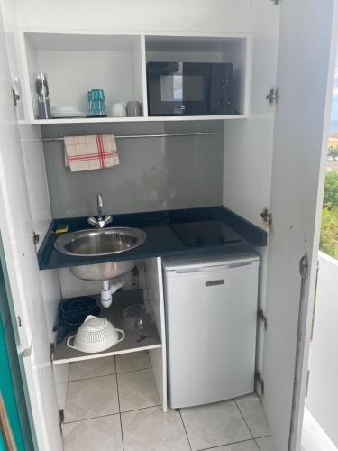 a small kitchen with a sink and a microwave at Beautiful Day Studio in Les Trois-Îlets