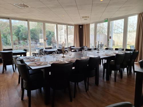 a large dining room with tables and chairs and windows at Hotell Toftalund in Halmstad