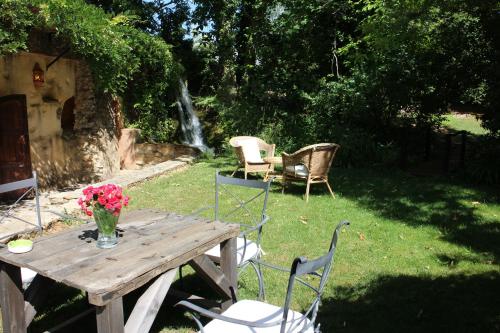 a wooden table with chairs and a vase of flowers at Molinos de Fuenteheridos in Fuenteheridos
