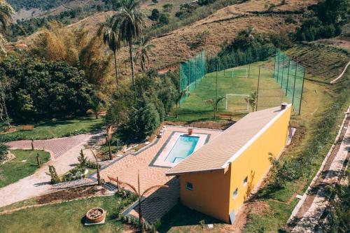 uma vista aérea de uma casa com piscina em Casa de Campo com lazer , pássaros e muito verde. em Poços de Caldas