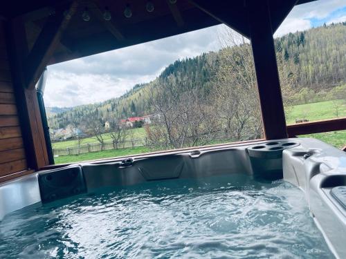 a hot tub with a view of a mountain at Domek RajskiRaj in Rajcza