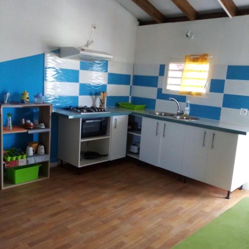 una cucina con pareti a righe blu e bianche e un lavandino di Akaz a Lamentin