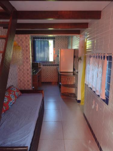 a small room with a bed and a kitchen at Casa Girassol in Itaparica